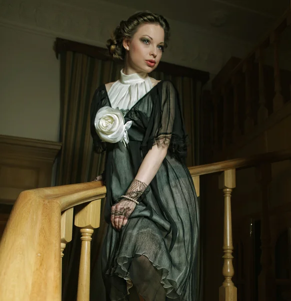 Woman in elegant dress posing on stairs — Stock Photo, Image