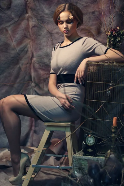 Modelo de moda sentado em um banquinho — Fotografia de Stock