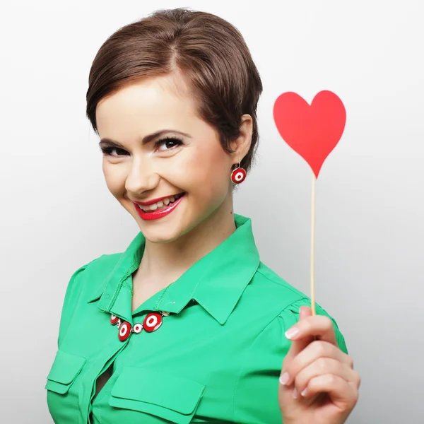 Jeune femme heureuse tenant coeur de papier rouge — Photo