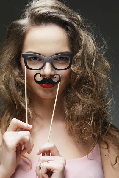 Mujeres jóvenes juguetonas sosteniendo unas gafas de fiesta . — Foto de Stock