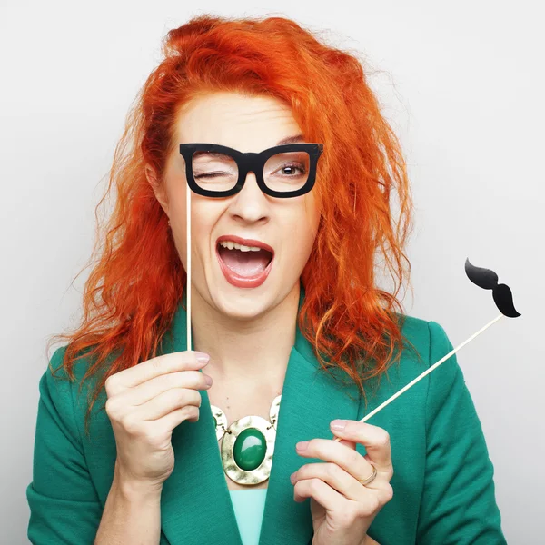 Mujer joven sosteniendo bigote y gafas — Foto de Stock