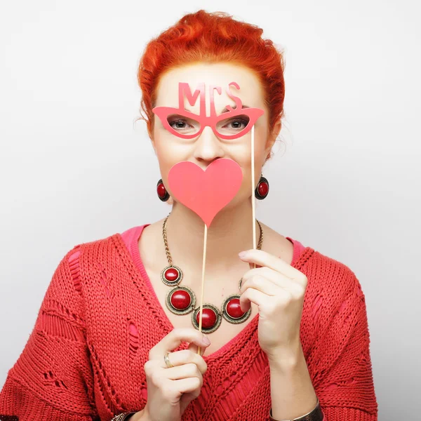 Mujer sosteniendo un partido corazón y gafas . — Foto de Stock