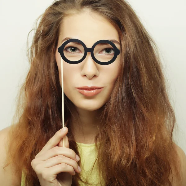 Mujeres jóvenes juguetonas sosteniendo unas gafas de fiesta . — Foto de Stock