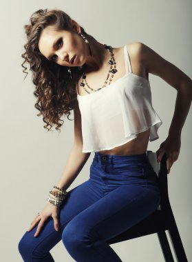 Sandalyede oturan genç manken