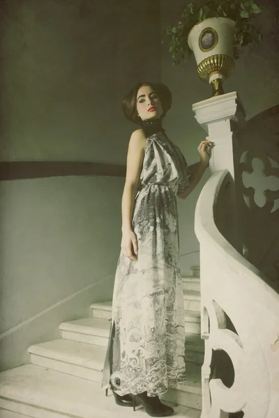 Elegancka kobieta w długiej sukni na wzór schodów — Zdjęcie stockowe