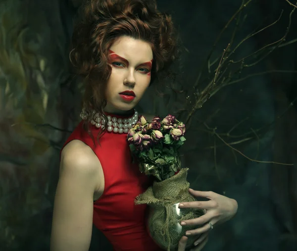 Красивая девушка с сухими розами — стоковое фото
