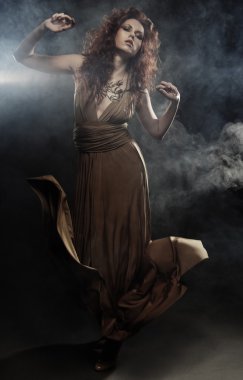 Bej renkli uzun elbiseli genç kadın.