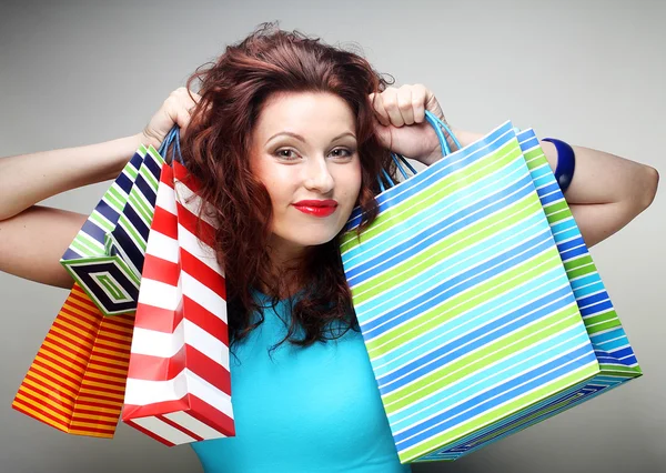 Hermosa mujer joven con bolsas de compras de colores — Foto de Stock