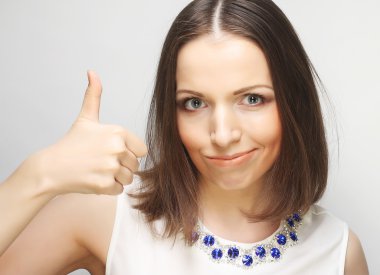 Başarılı kız başparmağını iki eliyle kaldırır.