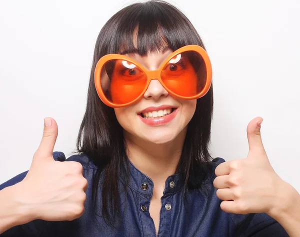 Jonge gelukkig vrouw met grote oranje zonnebril — Stockfoto