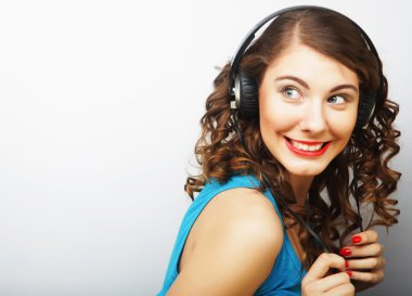 Kulaklıklı genç kıvırcık kadın müzik dinliyor..