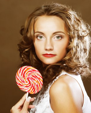 bir lolipop onun elinde olan kıvırcık kız