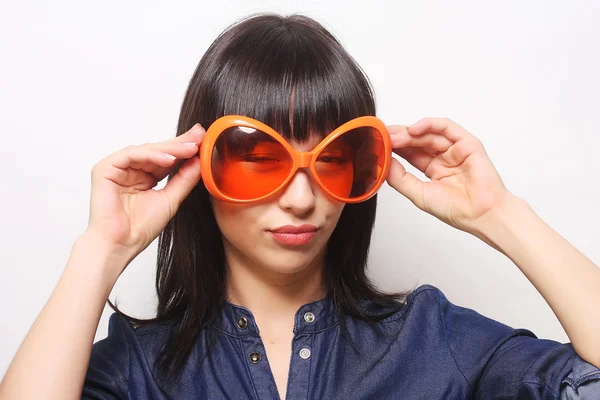 Jonge gelukkig vrouw met grote oranje zonnebril — Stockfoto