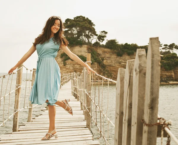 Ung glad kvinna på bron nära havet — Stockfoto