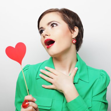 Kırmızı kağıt kalp tutan genç mutlu kadın