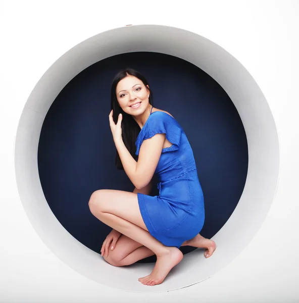 Brünette in blauem Kleid sitzt im Kreis — Stockfoto