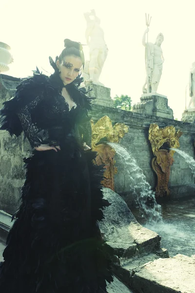 Модель моды позирует рядом с фонтаном в летнем парке — стоковое фото