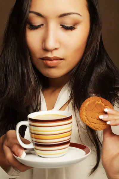 Asian woman with coffee and cookies. — Stock Photo, Image