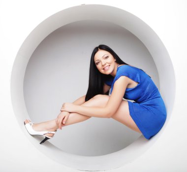 Mavi elbiseli esmer daire çiziyor.