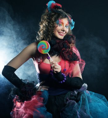 Yaratıcı makyajlı kız lolipop tutuyor.