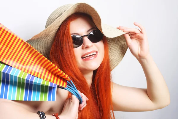 Ruiva mulher de compras usando óculos de sol e chapéu — Fotografia de Stock