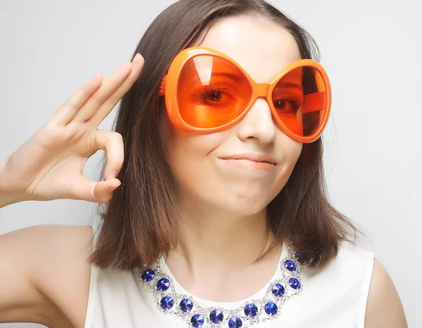 Mujer feliz joven con grandes gafas de sol naranjas —  Fotos de Stock