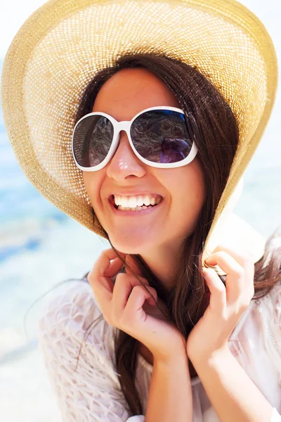 Счастливая женщина в шляпе на пляже — стоковое фото