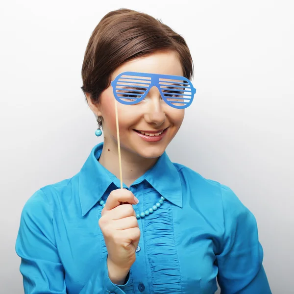 Mujeres jóvenes juguetonas sosteniendo unas gafas de fiesta . — Foto de Stock