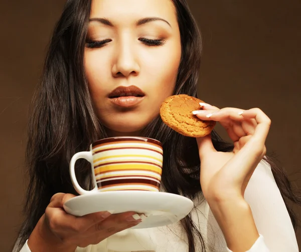 Asian woman with coffee and cookies. — Stock Photo, Image