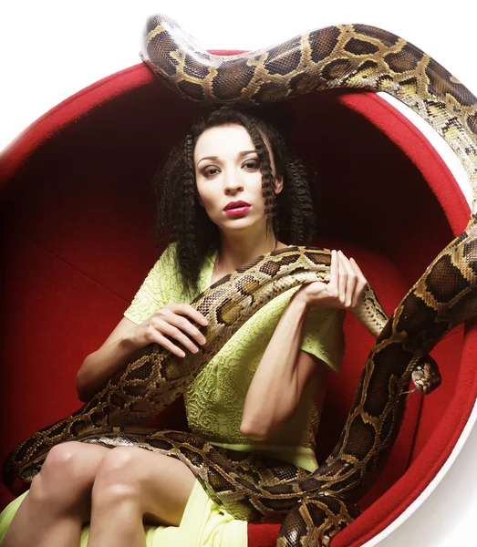 Woman in red chair holdung python — Stock Photo, Image