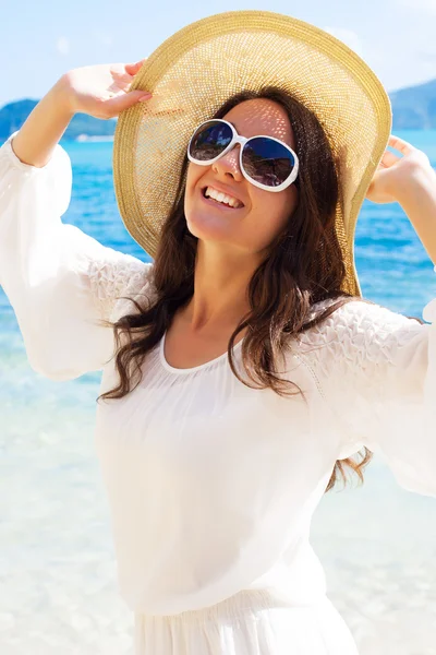 Mujer feliz en sombrero en la playa — Foto de Stock