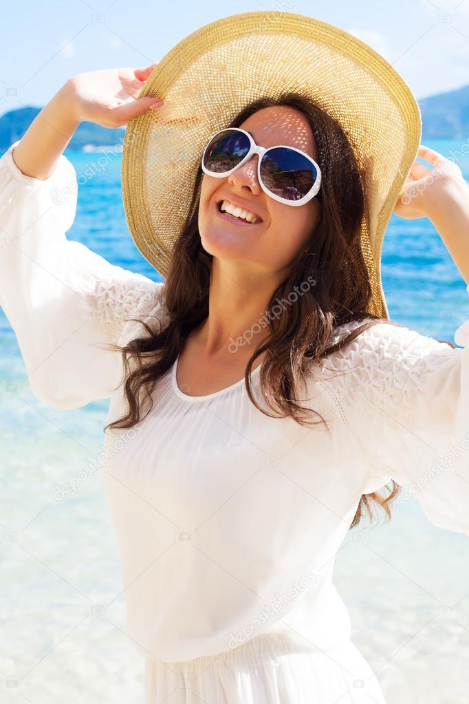 Happy woman in hat on the beach