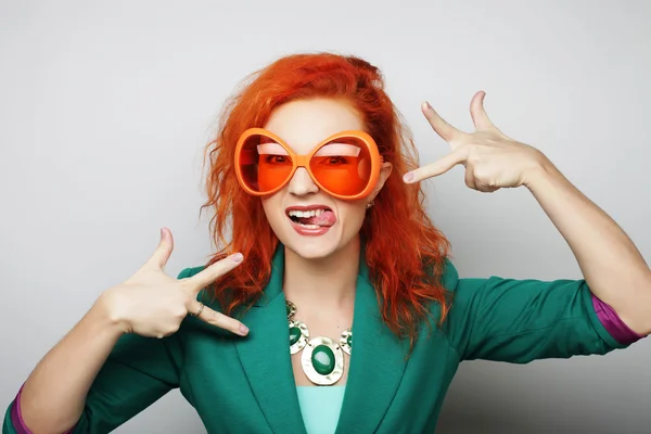 Mujeres jóvenes juguetonas sosteniendo unas gafas de fiesta . — Foto de Stock