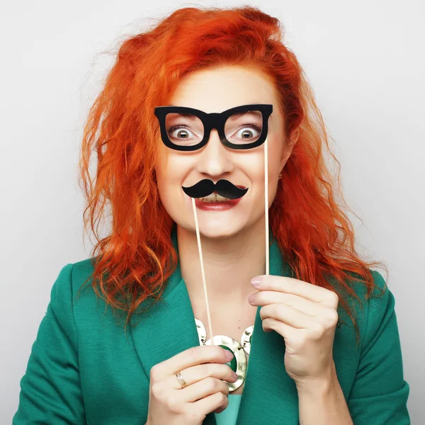 Mujer joven sosteniendo bigote y gafas — Foto de Stock