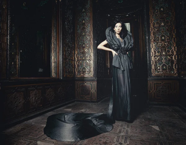 Молода красива жінка стоїть в палацовій кімнаті — стокове фото