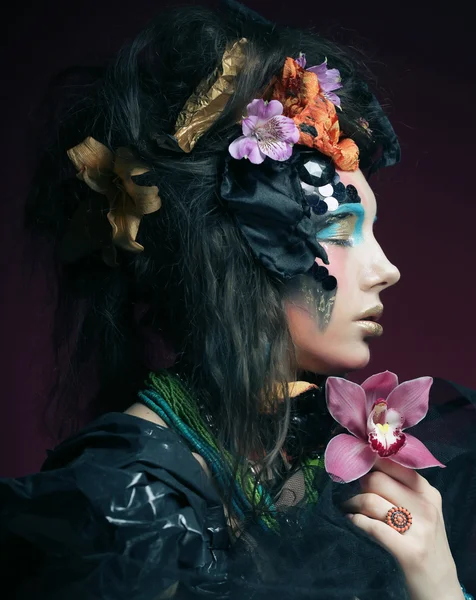 Γυναίκα με δημιουργικό μακιγιάζ εκμετάλλευση ροζ λουλούδι — Φωτογραφία Αρχείου