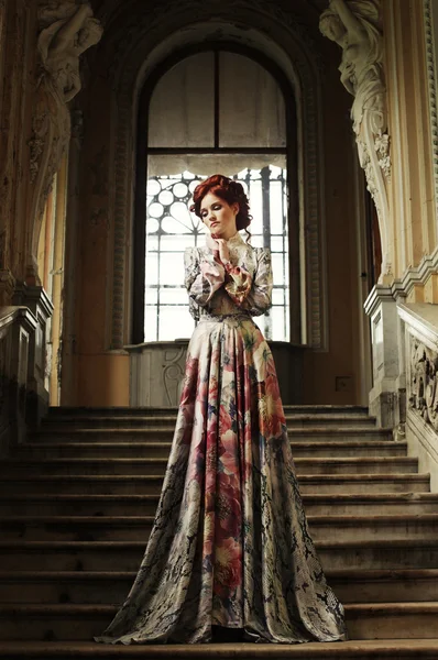 Vrouw in elegante jurk poseren op trap — Stockfoto