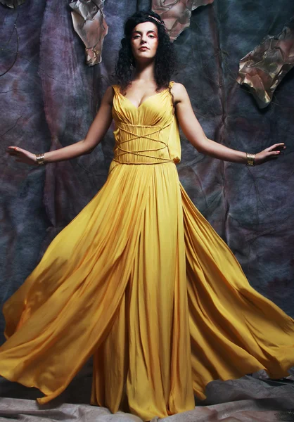 Mulher morena usando vestido de noite amarelo — Fotografia de Stock