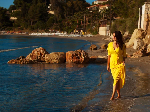 Kvinna med gul klänning på en strand. — Stockfoto