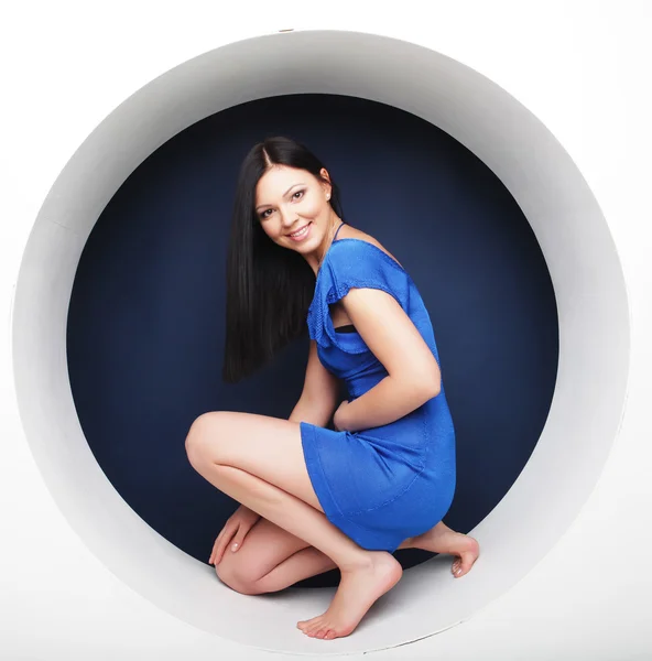 Morena em vestido azul sentado em um círculo — Fotografia de Stock