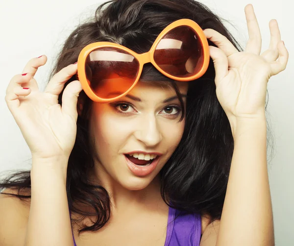 Mujer joven con grandes gafas de sol naranjas — Foto de Stock