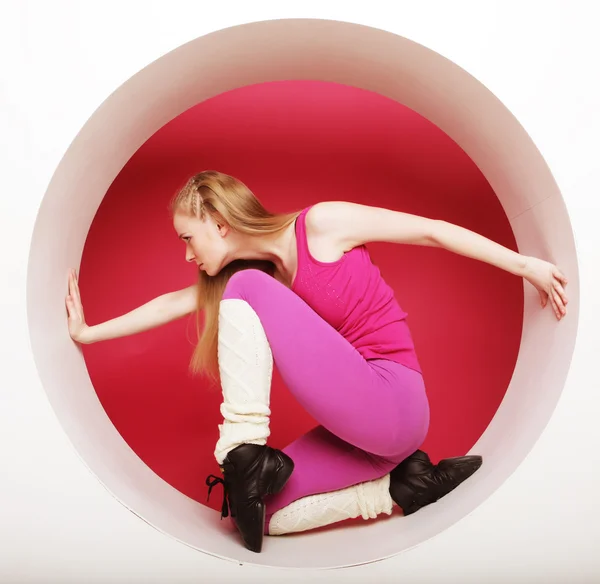 スポーティな女性がピンク色の丸のポーズ — ストック写真