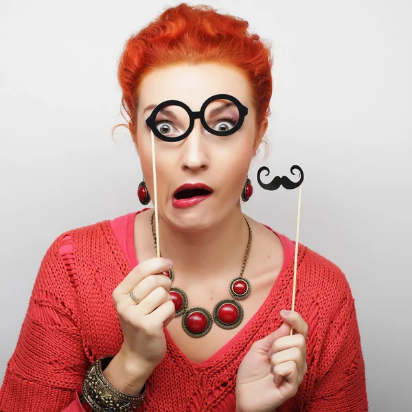 Woman holding mustache and glasses on a stick. — Stock Photo, Image