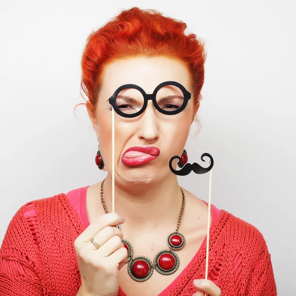 Woman holding mustache and glasses on a stick. — Stock Photo, Image