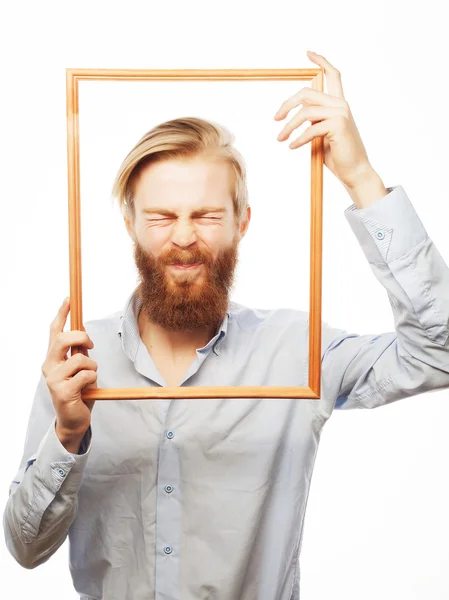 Hombre joven sosteniendo marco de imagen — Foto de Stock