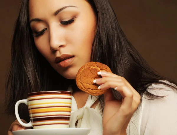Asian woman with coffee and cookies. — Stock Photo, Image