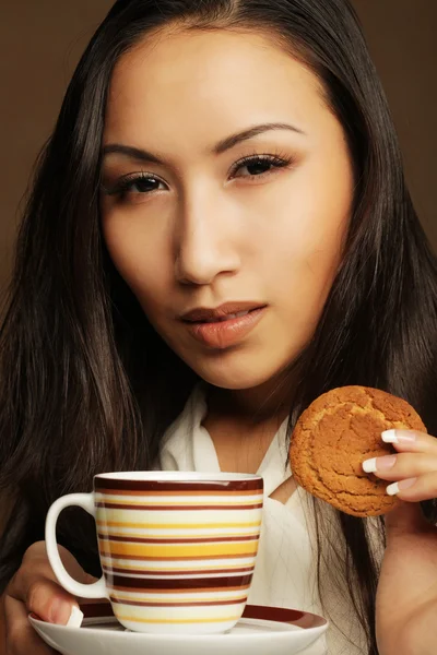 Asiatin mit Kaffee und Keksen. — Stockfoto