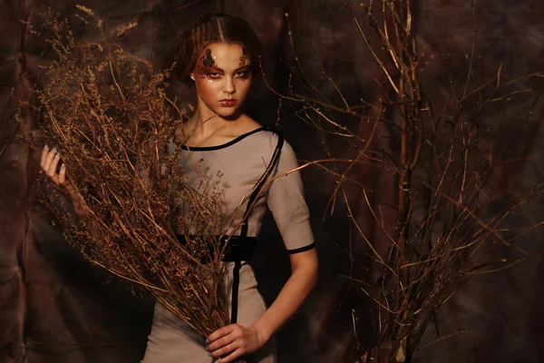 Woman with bright make up with dry branches — Stock Photo, Image