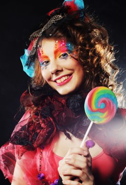Yaratıcı makyajlı kız lolipop tutuyor.