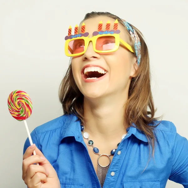 Woman wearing big sunglasses holding lollipop — Stock Photo, Image